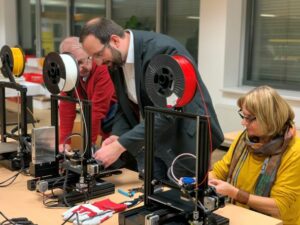 Johannes Kirchmayer of the Hilfsgemeinschaft introduces guests into the utilization of a 3D printer